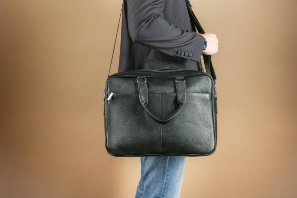 istock man holds leather briefcase close up, studio photo shot 1388033601