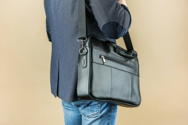 istock man holds leather briefcase close up, studio photo shot 1388033816