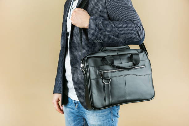 man holds leather briefcase close up, studio photo shot