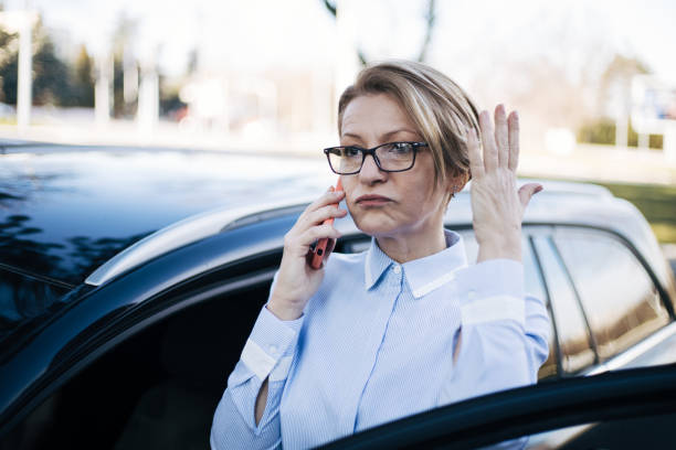 istock Mature woman standing by a car. 1388035293