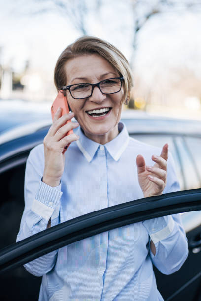 istock Mature woman standing by a car. 1388035338