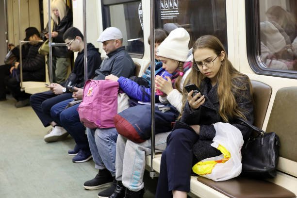 Moscow, Russia - March 2022: People sitting in a Moscow metro train with smartphones