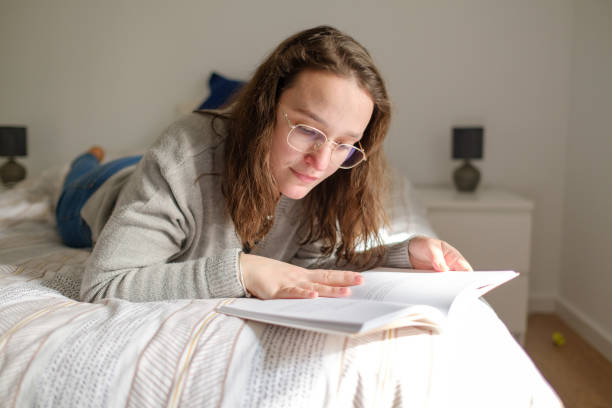 istock Woman enjoying her book in bed 1388040632
