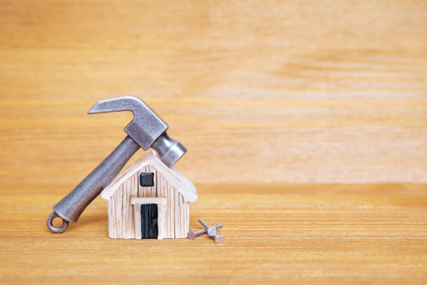 istock Hammer and nails by a house model on a wooden table 1388042108