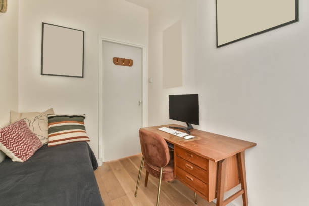 The interior of a spacious bedroom with a bed and a workplace with a computer opposite