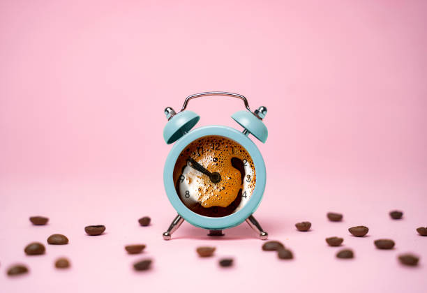 istock Beautiful teal alarm clock watch , black coffee pored inside 1388046831