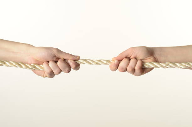 istock male and female hands pull the rope on a white background close-up 1388058914