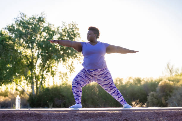 Active Lifestyle An African American woman doing yoga outdoors. warrior 2 stock pictures, royalty-free photos & images