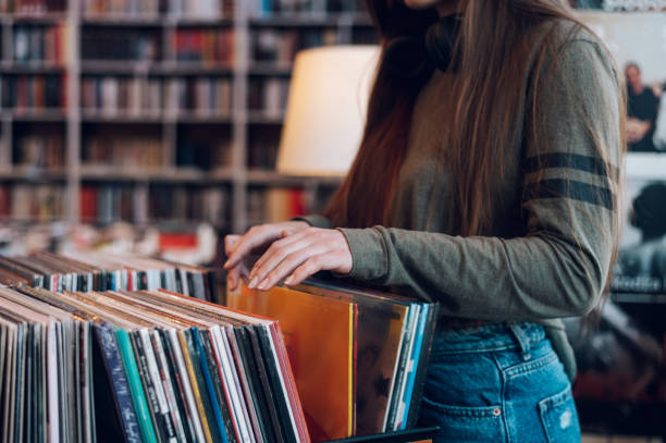 istock Woman hands choosing vinyl record in music record shop 1388068607