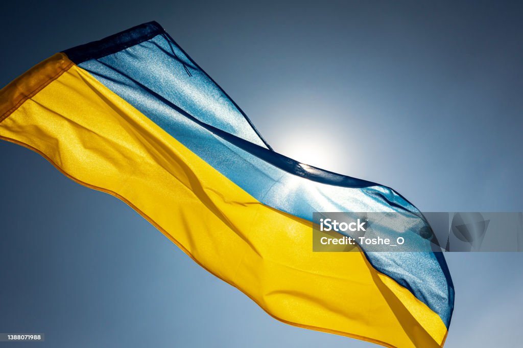 National flag of Ukraine National flag of Ukraine waving outside on a wing facing the bright sky and the Sun Ukraine Stock Photo