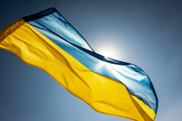 National flag of Ukraine National flag of Ukraine waving outside on a wing facing the bright sky and the Sun ukrainian language stock pictures, royalty-free photos & images