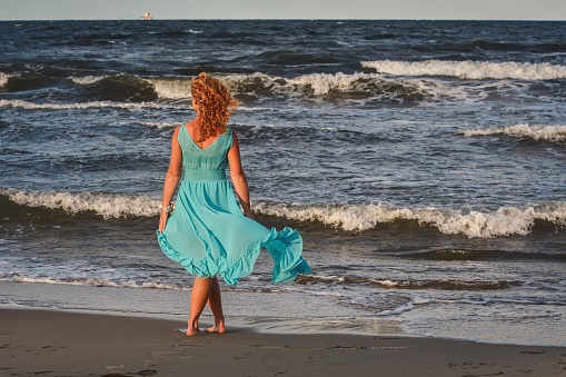 Girl in a blue dress at the Polish seaside.