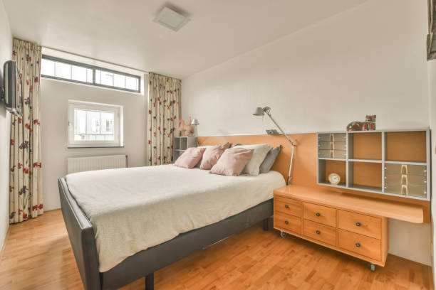 istock Cozy bedroom design with a large white bed 1388074644