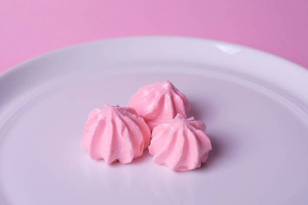 istock Pink meringues on a plate with a pink background 1388077546