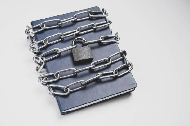 istock The book is locked under lock and key on a white background. Secret archive. 1388080440