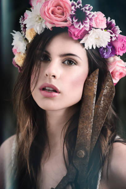 portrait d’une belle jeune femme portant une couronne de tête florale et tenant des cisailles - goddess venus aphrodite caucasian photos et images de collection