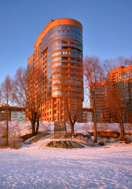 A new house on the river bank. Multi-storey new building on the snowy bank of the Ob. Novosibirsk, Siberia, Russia, 2022