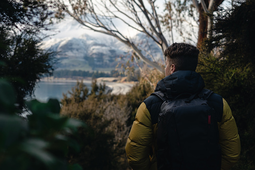 Man with backpack walking among the forest. Horizontal