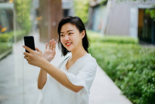 istock Smiling Asian businesswoman using smartphone for video call 1388096494