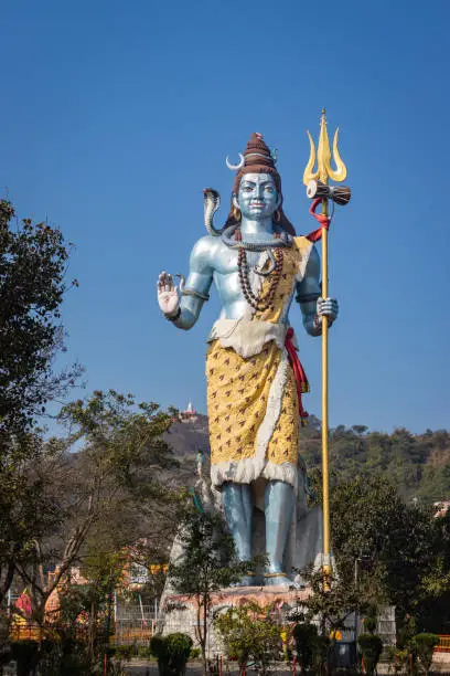 hindu god shiva statue with bright blue sky background at morning from different angle image is taken at haridwar uttrakhand india.