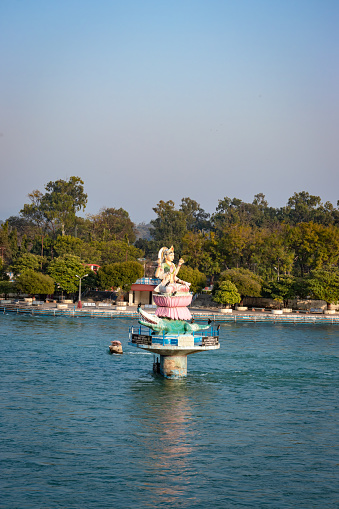hindu goddess statue in the middle of ganges river with flat sky image is taken at haridwar uttrakhand india.