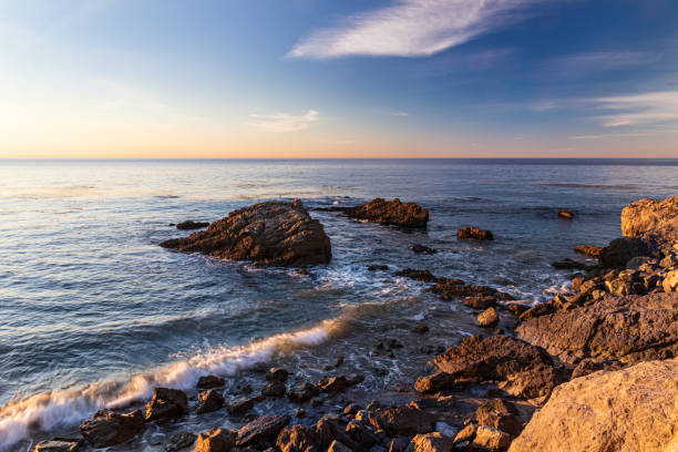 istock Rocky shore with gentle waves; calm ocean. Blue sky and clouds 1388103921