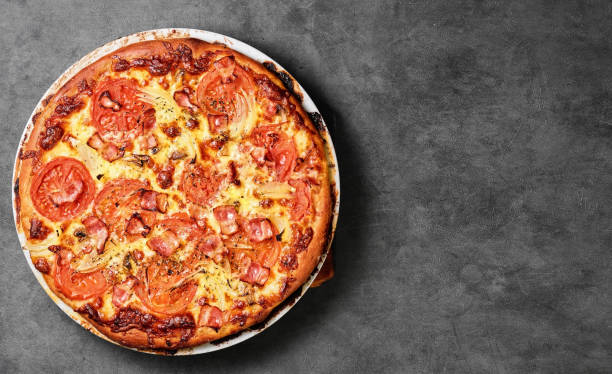 istock Traditional Italian pizza with mushrooms, mozzarella tomatoes and bacon. Top view, layout on a gray table, free space for your text. Country style. 1388106162