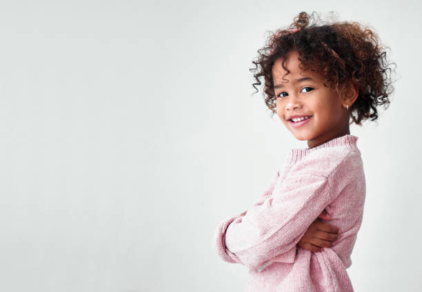 Shot of a little girl standing with crossed arms against a grey background She’s laughter and joy 4 year old girl stock pictures, royalty-free photos & images