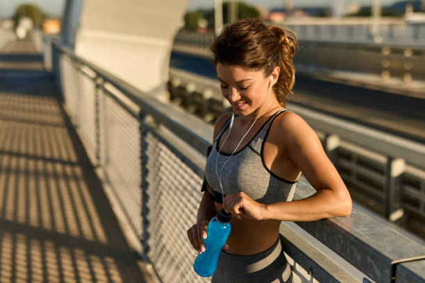 istock Sportswoman resting and hydrating on the bridge 1388106569