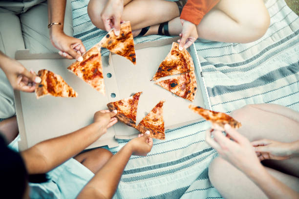 istock Shot of an unrecognizable friends sharing pizza outside 1388107701