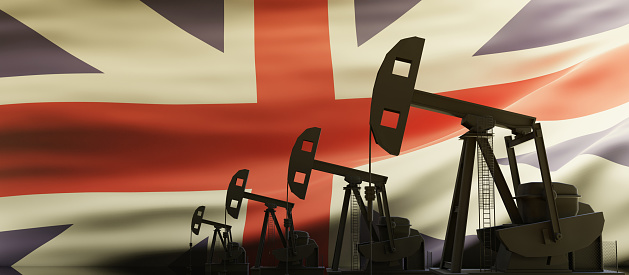 Oil and gas production in UK. Pumpjack drilling on United Kingdom flag background. Petroleum fuel industry in the country. 3d render