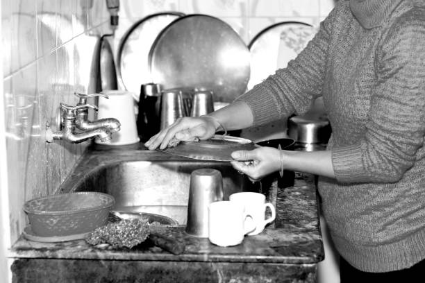 istock Women washes dishes in kitchen 1388108074