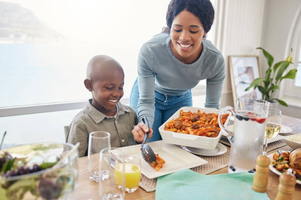 zdjęcie matki jedzącej jedzenie dla syna w domu - dishing out zdjęcia i obrazy z banku zdjęć