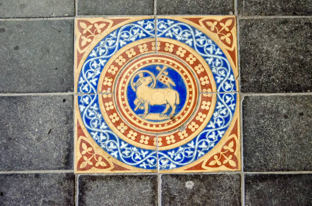 A handcrafted Victorian tile showing the lamb and flag Christian symbol on the floor of an historic church in England.