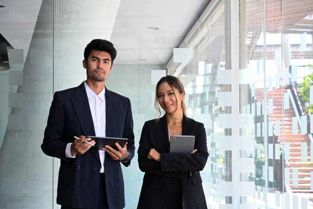 istock Two professional businesspeople holding digital tablet and looking confidently at camera. 1388114950