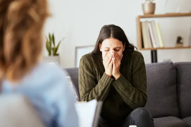 Photo of Shot of a young woman having a therapeutic session with a psychologist