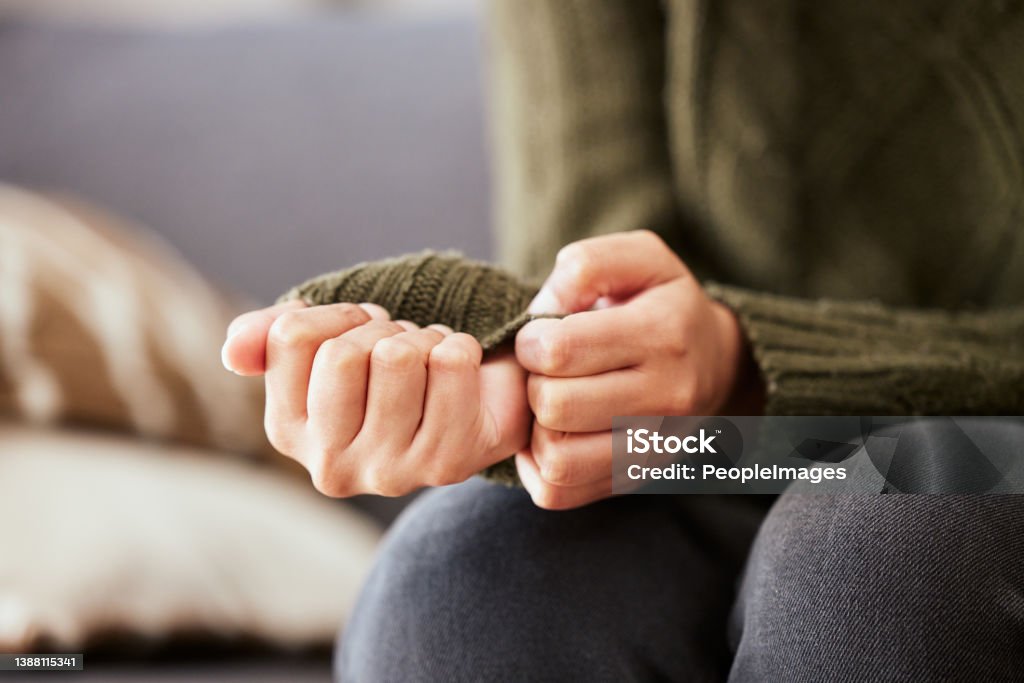 Shot of a unrecognizable woman sitting on a sofa and feeling anxious It’s about understanding myself Anxiety Stock Photo