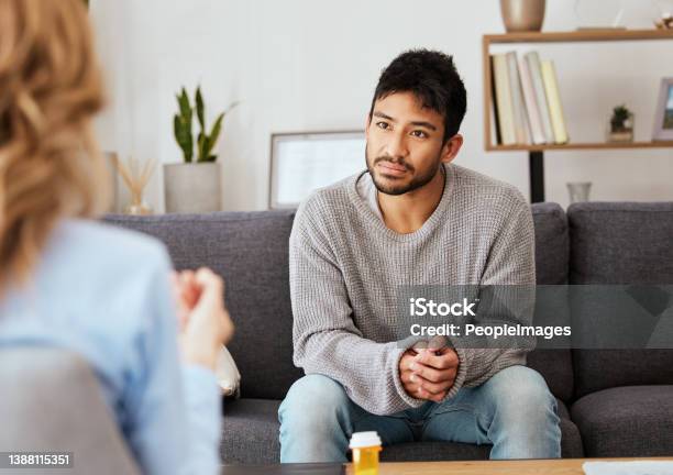 Shot Of A Young Man Having A Therapeutic Session With A Psychologist Stock Photo - Download Image Now