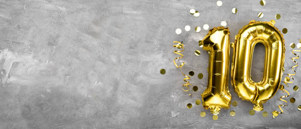 Yellow foil balloon number, number ten on a concrete background. 10th birthday card. Anniversary concept. for anniversary, birthday, new year celebration. banner, Yellow foil balloon number, number ten on a concrete background. 10th birthday card. Anniversary concept. for anniversary, birthday, new year celebration. banner, copy space. 10 balloon stock pictures, royalty-free photos & images