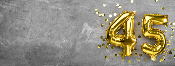 Yellow foil balloon number, number forty five concrete background. Greeting card with the inscription 45. Anniversary concept. for anniversary, birthday, new year celebration. banner, copy space.