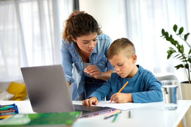 istock Mother helping her son with homework at home 1388117714