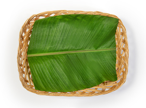Banana leaf in bamboo basket isolated on white background.