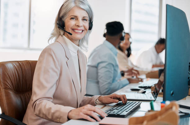 istock Shot of a mature agent sitting in the office and using her computer while her colleagues work behind her 1388118515