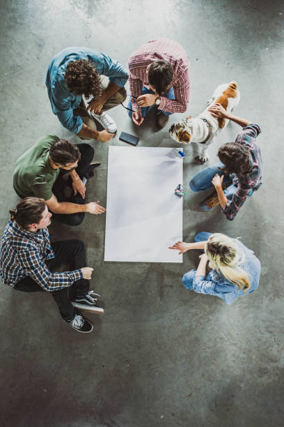 istock Above view of start up team working on plans at casual office. 1388120499