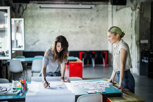 istock Young creative women drawing business plans in the office. 1388120681