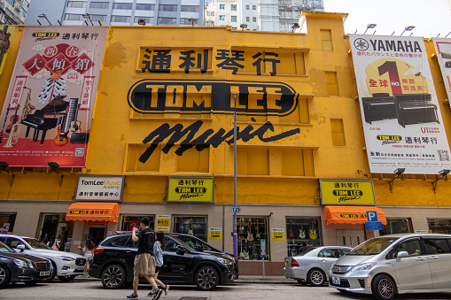 Hong Kong - March 26, 2022 : People walk past the Tom Lee Music store in Tsim Sha Tsui, Kowloon, Hong Kong.