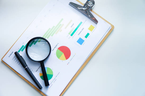 istock Magnifying glass and pen over graph on table. Financial concept. 1388125882