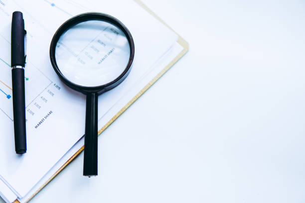 istock Magnifying glass and pen over graph on table. Financial concept. 1388126407