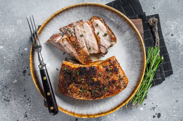 Filipino marinated pork belly with crust in a plate. Gray background. Top view Filipino marinated pork belly with crust in a plate. Gray background. Top view. cooked bacon slice stock pictures, royalty-free photos & images