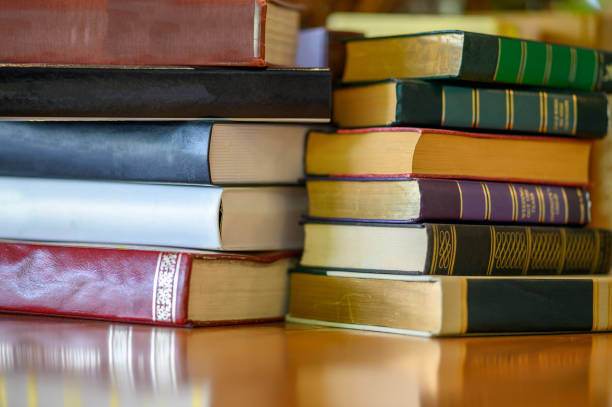 istock Old books stacked on a wooden table at the library. 1388128332